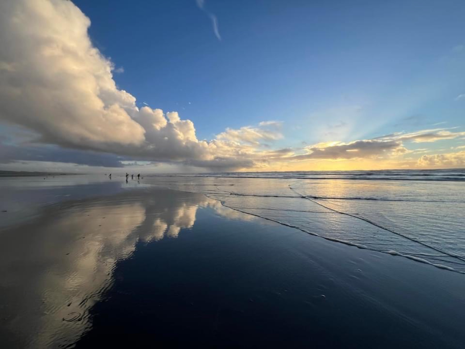 Ocean shoreline beneath a broad evening sky